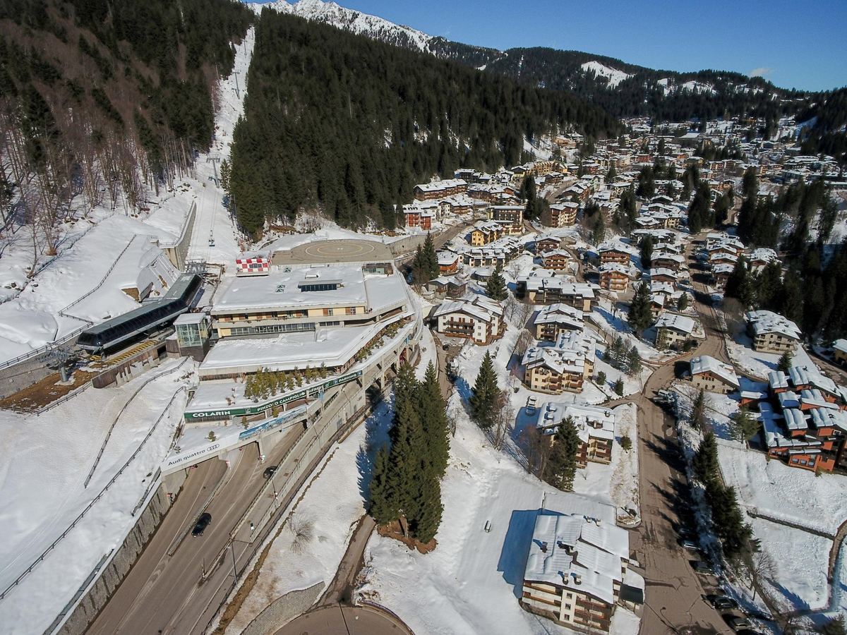 Veduta aerea di Madonna di Campiglio tra boschi di abeti e vette innevate delle Dolomiti di Brenta