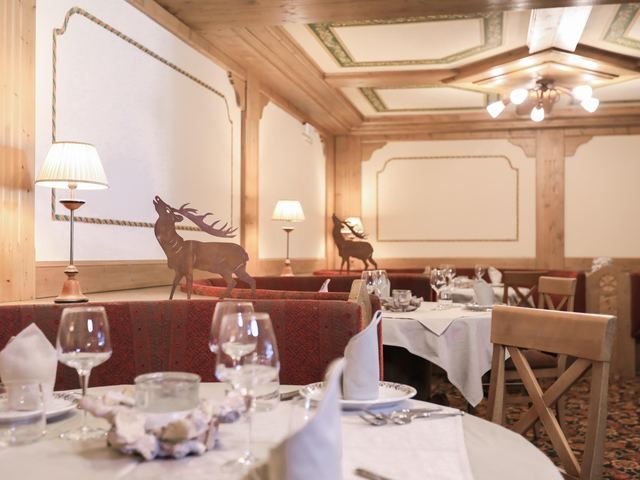 Sala ristorante con statuette di cervo e soffitto in legno decorato