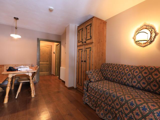 Zona giorno con armadio in legno intagliato e specchio decorato